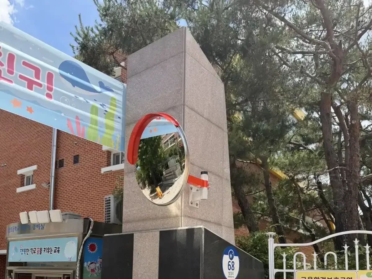 학교 정문 기둥에 설치된 도로반사경 클로즈업